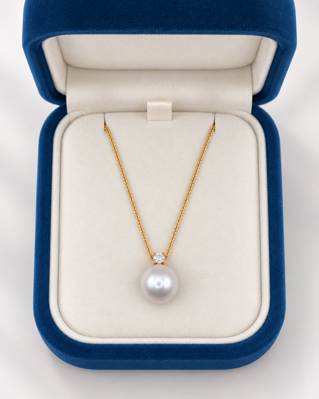 The 12mm white freshwater pearl V-bar necklace in a navy velvet jewelry box