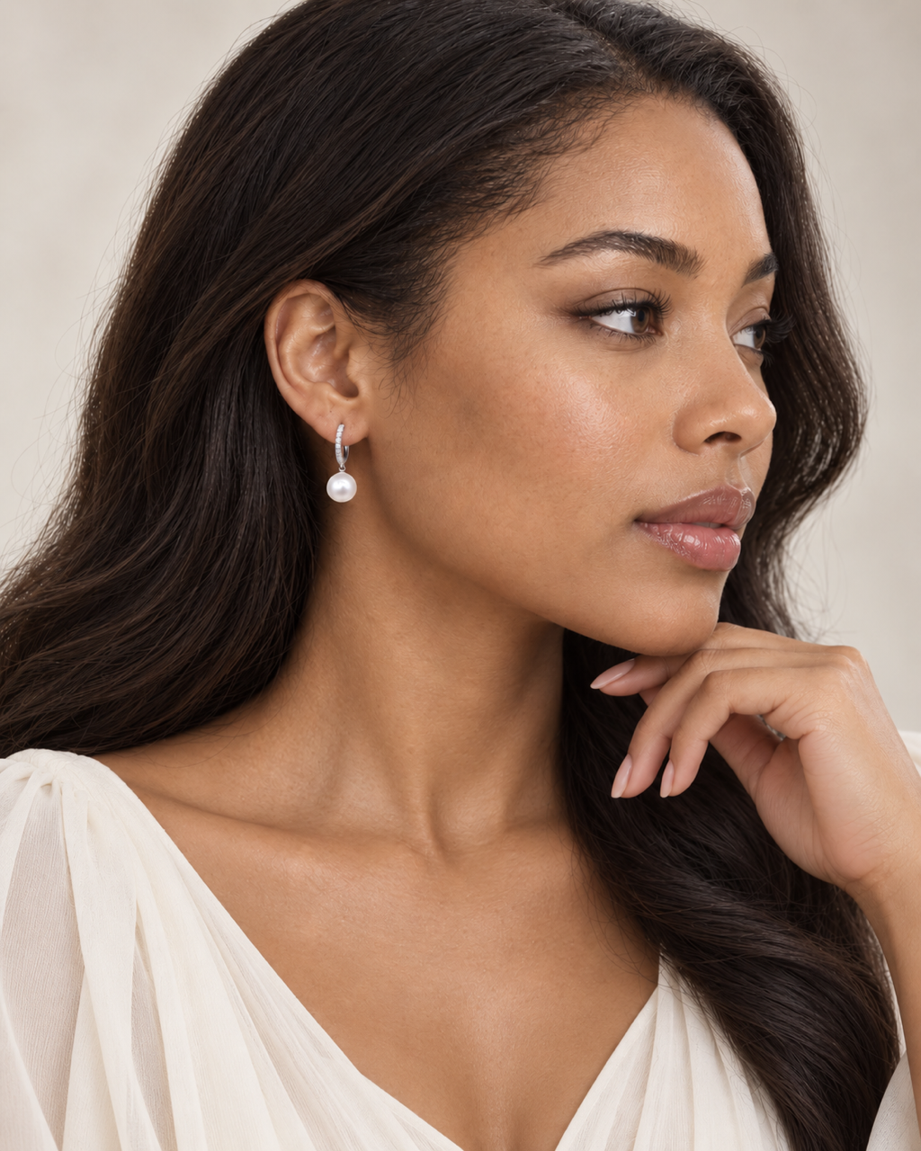 Model wearing the sterling silver pearl huggie drop earrings